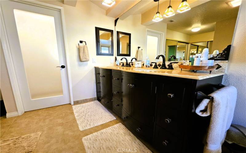 primary bath vanity, double sinks, frosted door into water closet with bidet