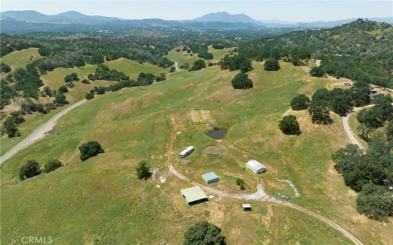 From bottom left, open barn, storage shed, and insulated shop.  Trailer and greenhouse structures are just above.