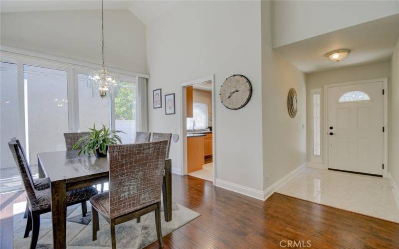 Dining area adjacent to the kitchen with high ceiling and sliding doors to the patio.