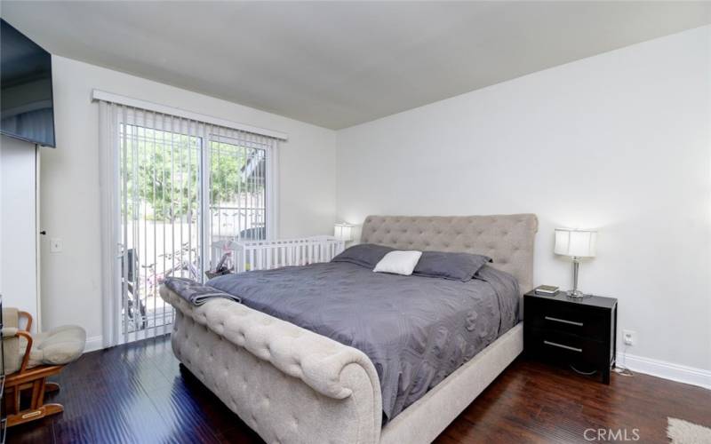 The master bedroom with space for a king size bed and a sliding door leading to a private patio.