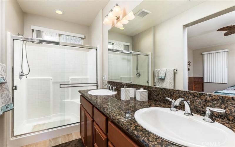 Primary bathroom with dual basins and large walk in shower.