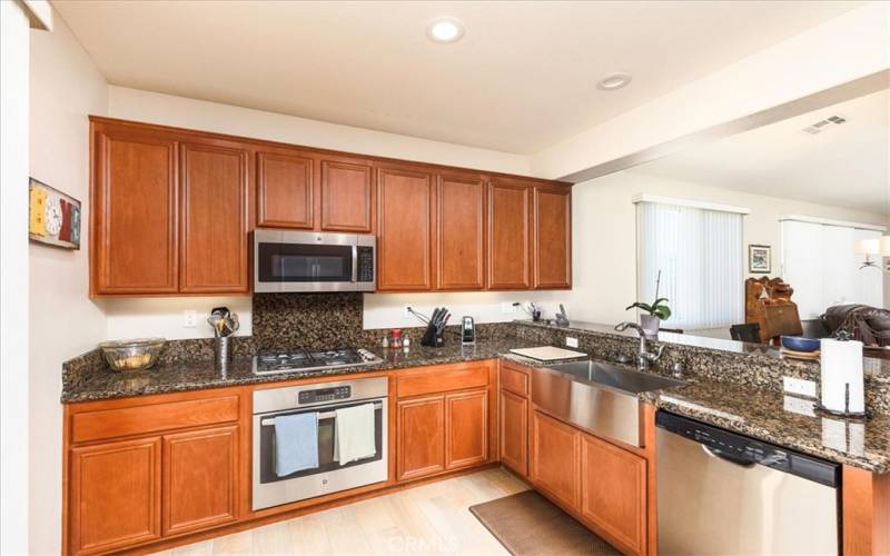 Attractive kitchen with granite counters, stainless steel appliances, farm style sink and breakfast bar.