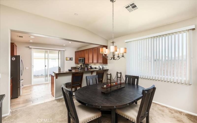 Dining area open to kitchen with sliding door out to large Alumawood covered patio.