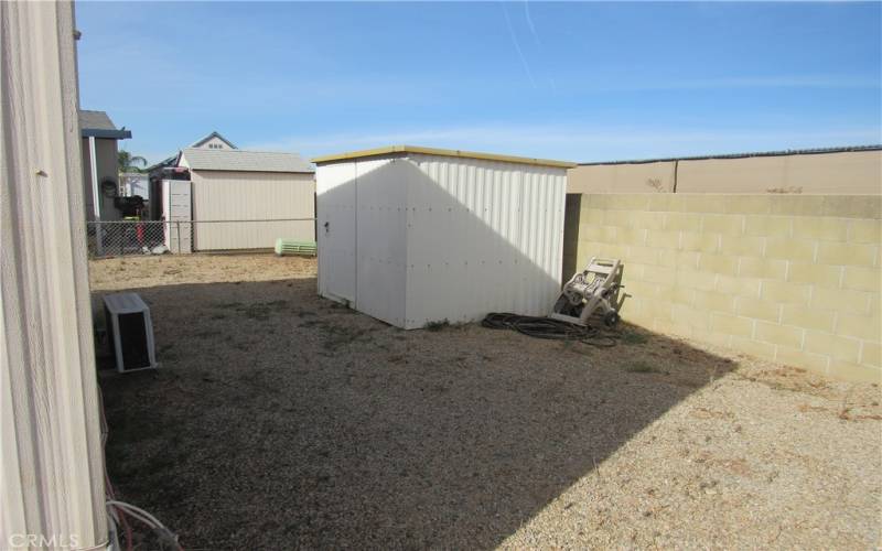 Fenced back yard with shed. Block wall in back