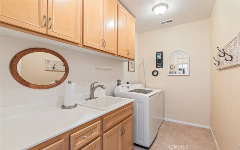 Indoor laundry room with sink and LOTS of storage