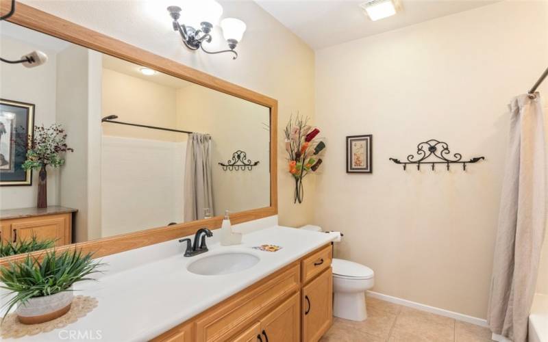 Second bathroom featuring large shower and storage