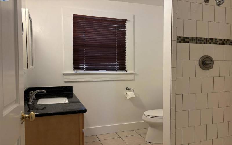 Ground level bathroom with upgraded cabinetry, tile and fixtures