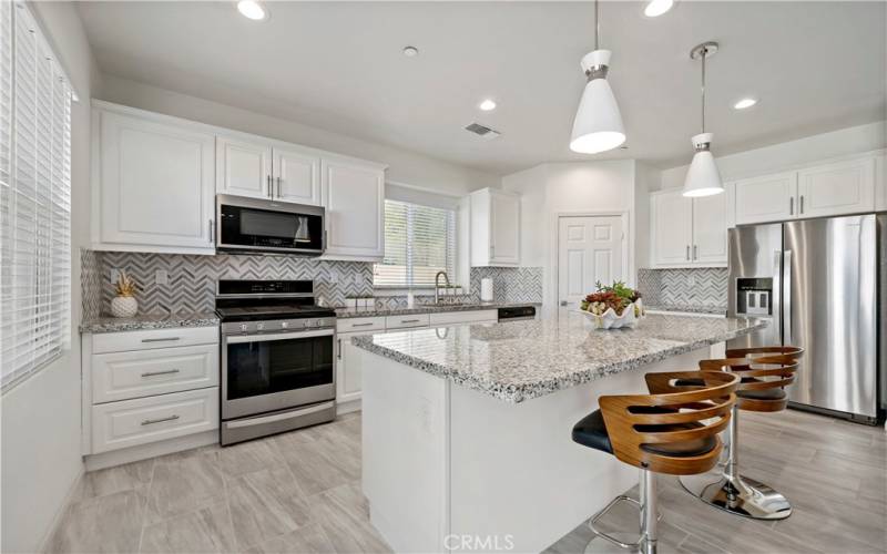 Kitchen with upgraded mosaic tile herringbone pattern extended backsplash