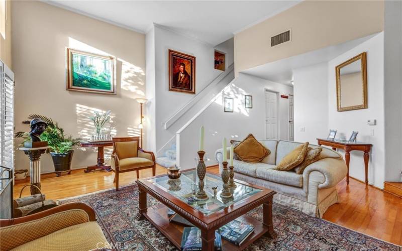 Living room w/ soating high ceiling, Wood floors, FPLC