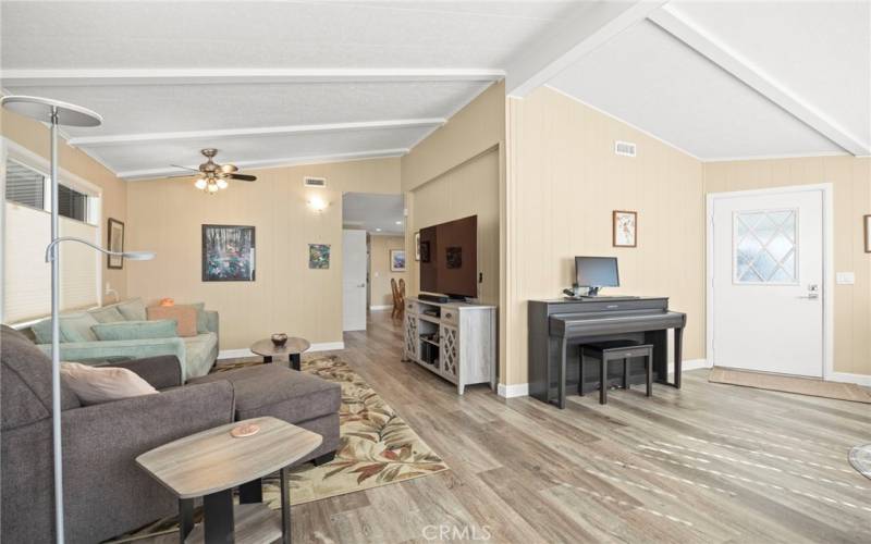 Living room area with ceiling fan w. remote, and window coverings.