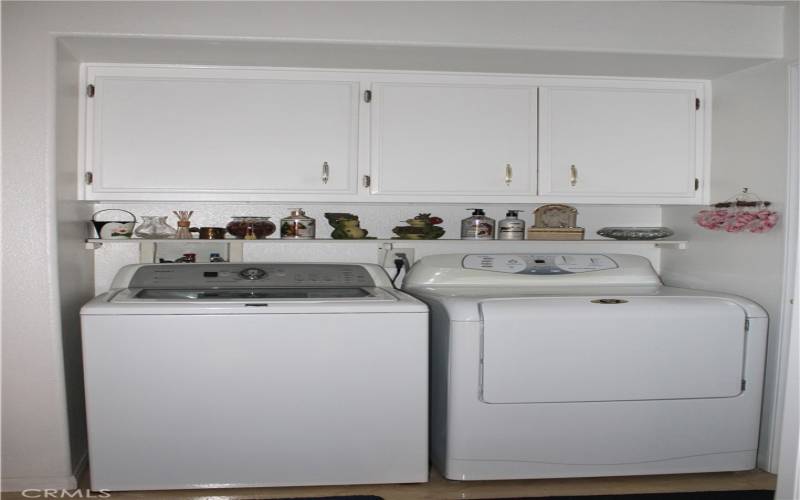 Washer/dryer with overhead cabinetry.