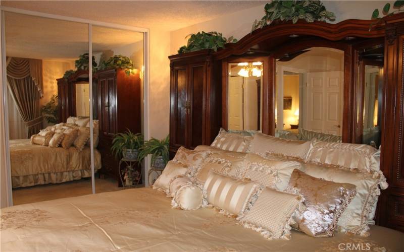 Primary bedroom with mirrored closet doors.