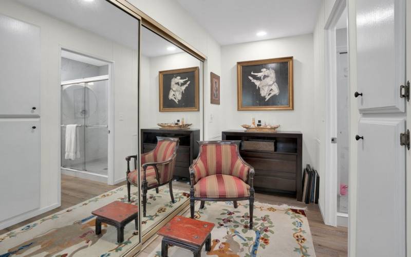 Large dressing area with storage, mirrored wardrobe doors and entry to en suite bathroom