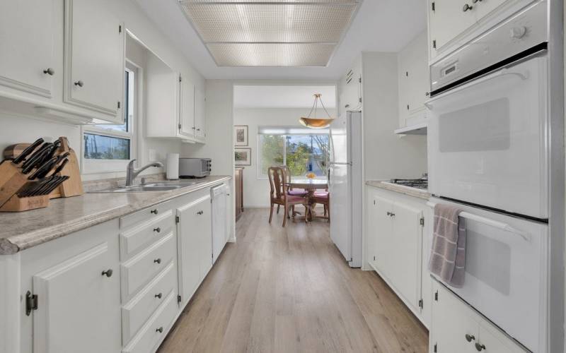 Galley kitchen with gas cooktop, double ovens, dishwasher, stainless steel sink and more!