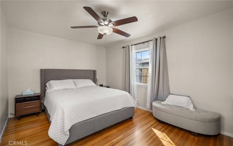 Generous sized bedroom one features a ceiling fan and window with a view to the oversized backyard.