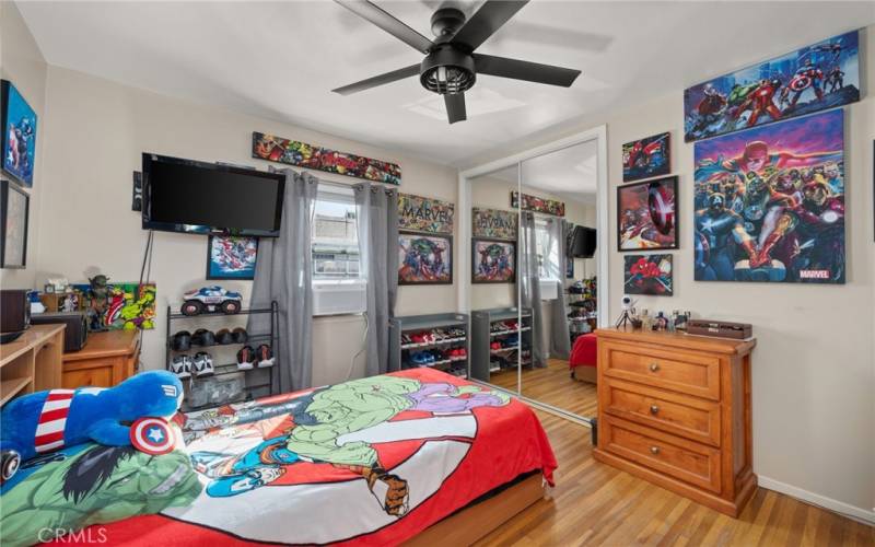 Bedroom three with ceiling fan and mirrored closed doors.