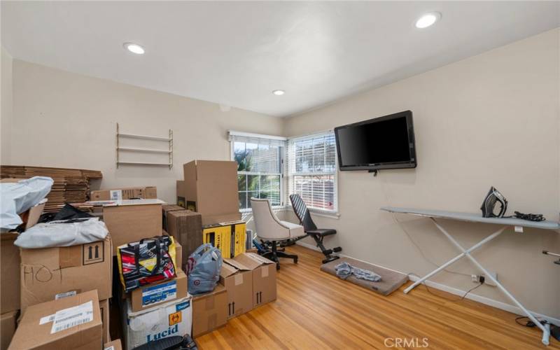 Bedroom four features recessed lighting, plenty of windows with a view of the front of the property, and a closet with mirrored doors.