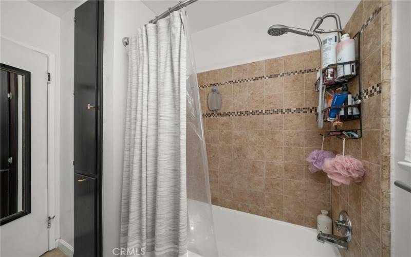 Decorative tile in bath/shower with linen closet.