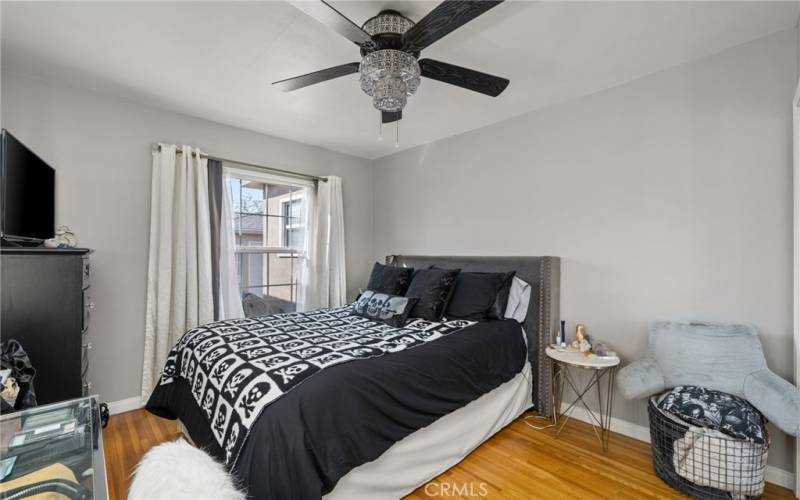 Second bedroom with ceiling fan and window with view to backyard.