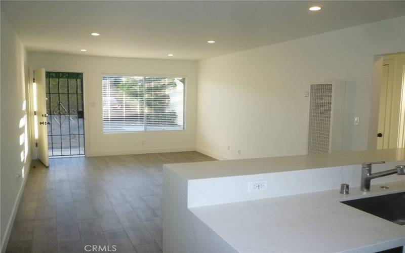 View from the eat-in kitchen looking towards the front door.  The flooring is tile plank and the counter tops are all quartz.