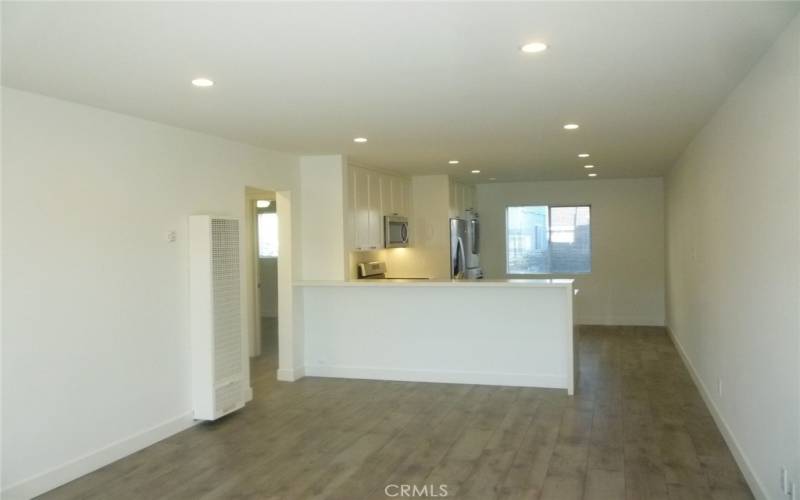 View of the living room and eat-in kitchen beyond as seen from the front door.