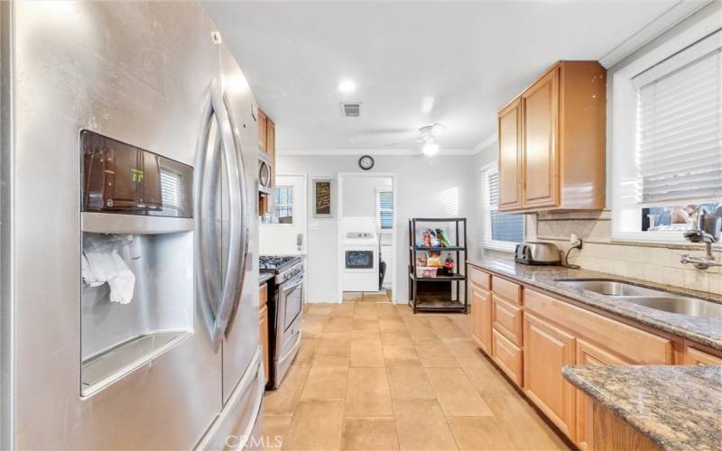 Spacious eat-in kitchen connects to laundry room and door leading to backyard.