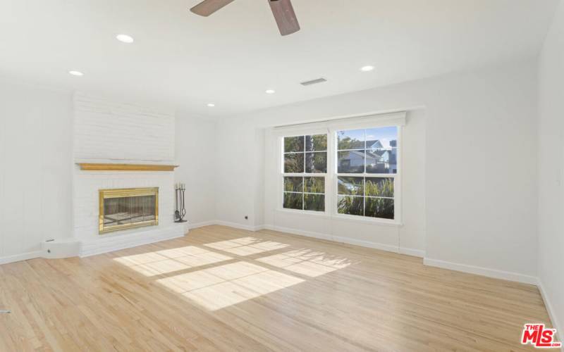 Living Room with fireplace & front windows streaming sunshine