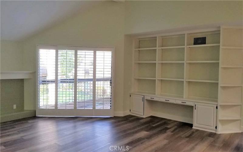 Very Large Master Bedroom with fireplace, built in shelving and balcony access.