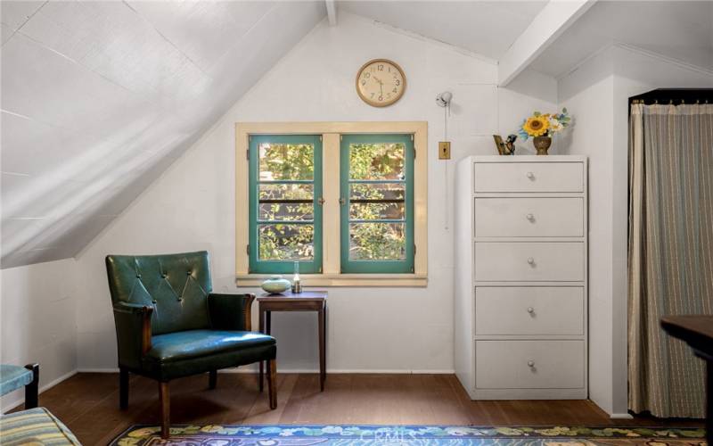 up the spiral staircase is a loft bedroom with storage space