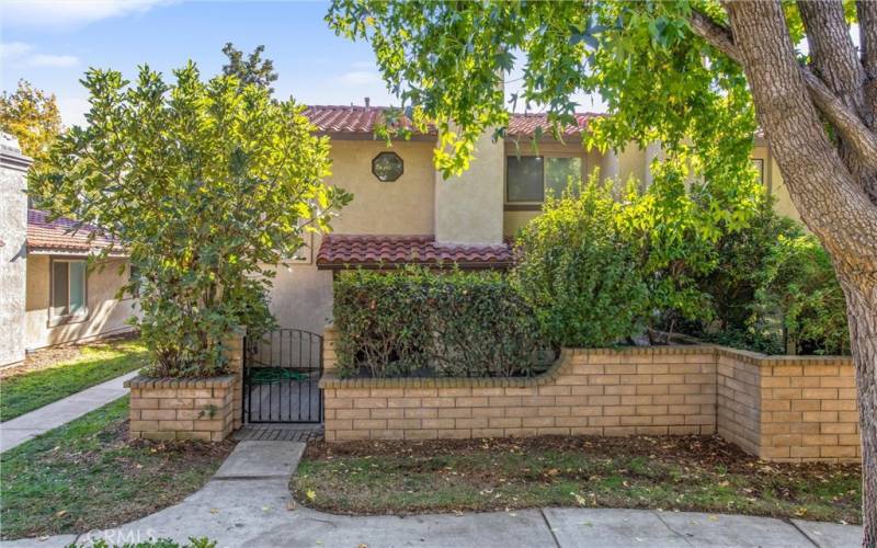 Front of home with private fenced court yard