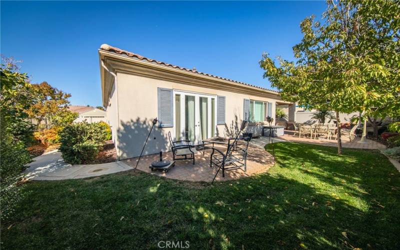 Grass area in the backyard. Primary Bedroom with French Doors in pictured here.