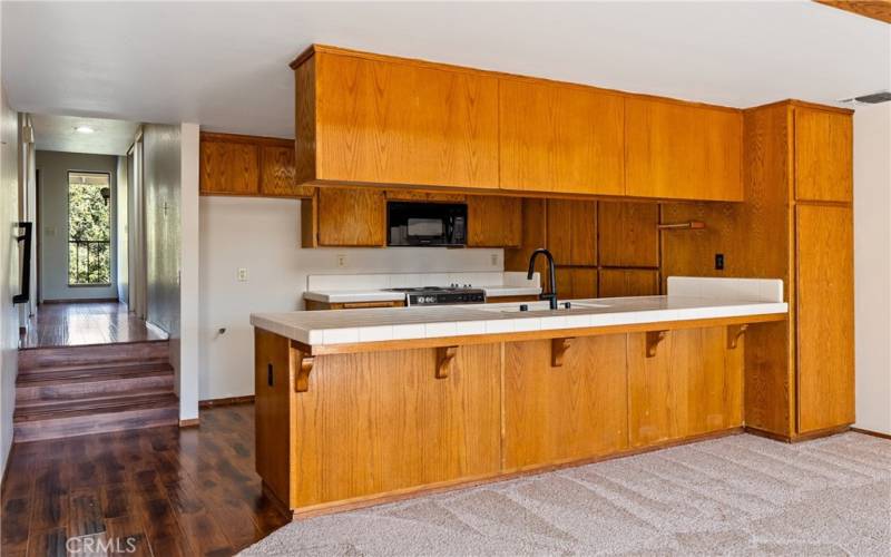 The long breakfast bar allows for a cozy informal eating area or simply keeping whoever is working in the kitchen company.