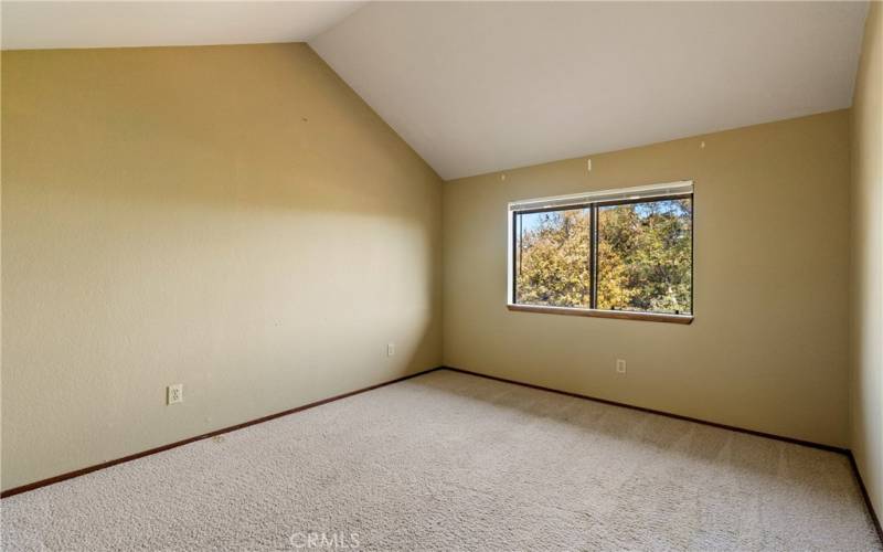 Bedroom 2 features a cathedral ceiling and large window to the front of the complex.