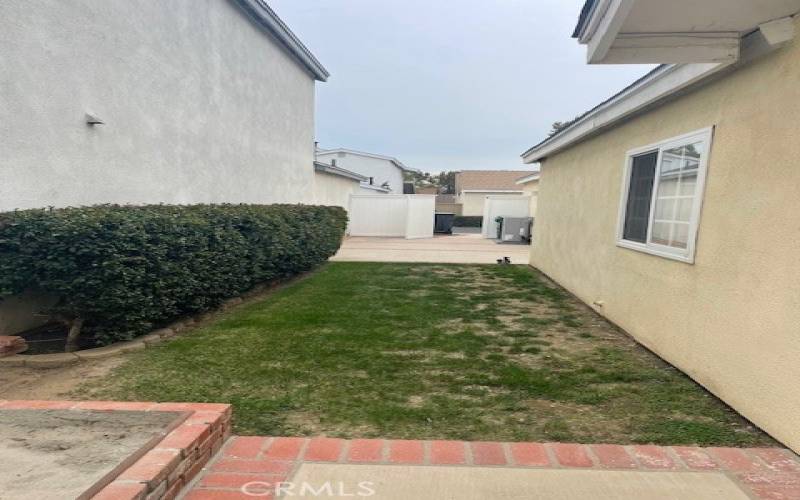 Side yard looking toward open gate near garage