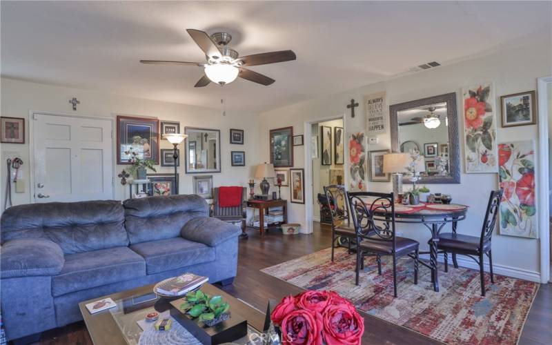 Spacious living room with ceiling fan & newer vinyl flooring