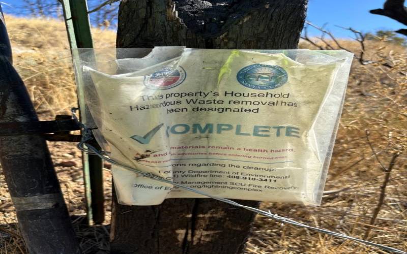 Sign posted on gate that reads Property's Household Hazardous Waste Removal Complete