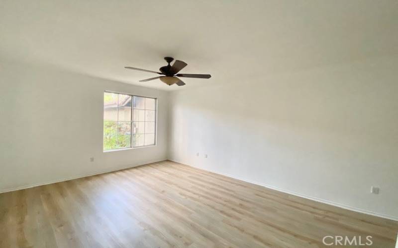 Large primary bedroom has new flooring throughout.