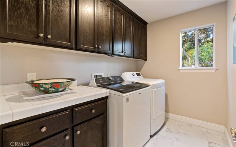 Laundry room with abundant cabinetry and countertop space