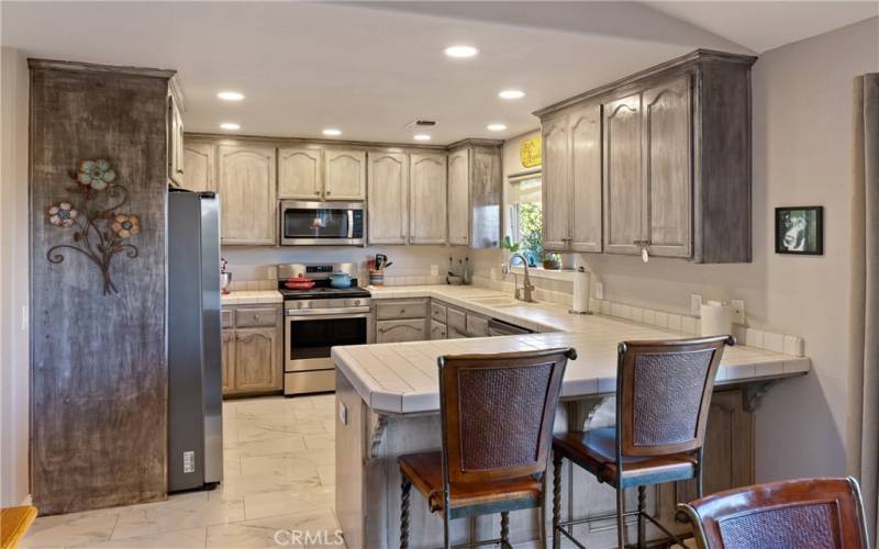 Let's step back inside to the kitchen, complete with beautiful tile floor and stainless steel appliances