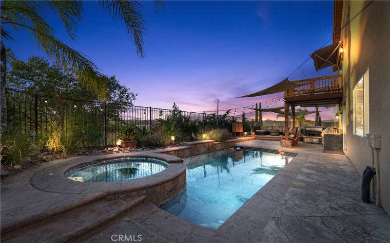 Backyard features a pool, spa, and outdoor kitchen