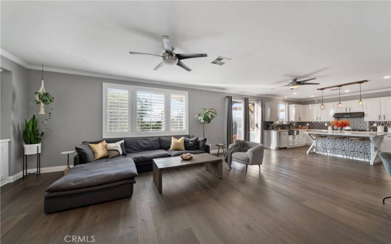 Great room with gas fireplace, ceiling fan, and built in desk area.