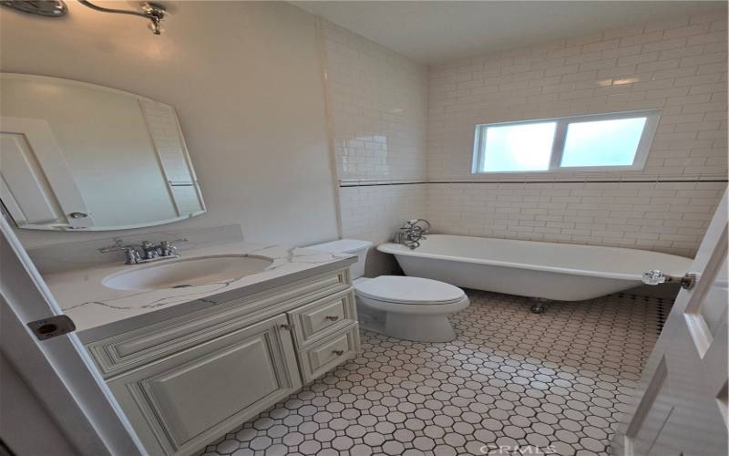 The guest bathroom has a clawfoot tub and gorgeous tile.