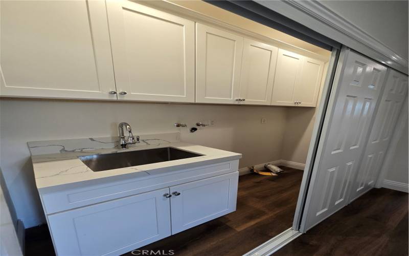 Centrally placed laundry area with sink and storage.