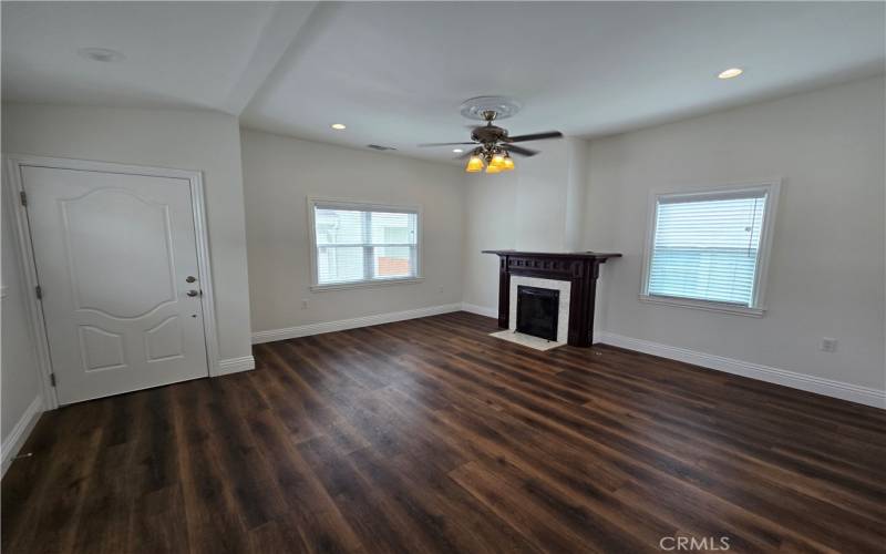 Entryway and living room complete with a working fireplace.