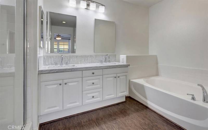 Primary bath with oval soaking tub, separate walk-in shower, dual sinks, separate primacy commode