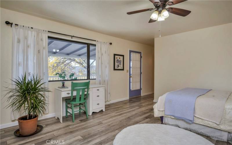 Primary bedroom suite opens to the back deck; bathroom is off at the right beyond the deck door.