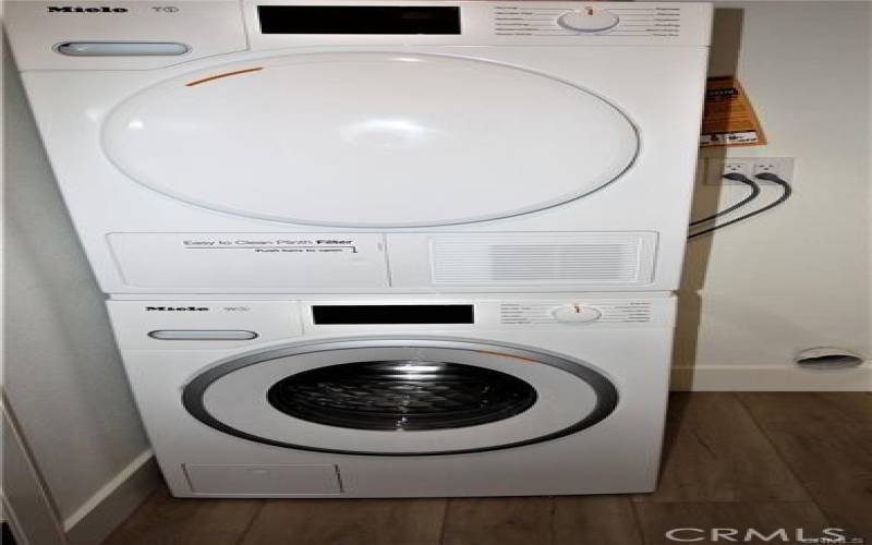 Stackable washer and dryer shared by three tenant's total.