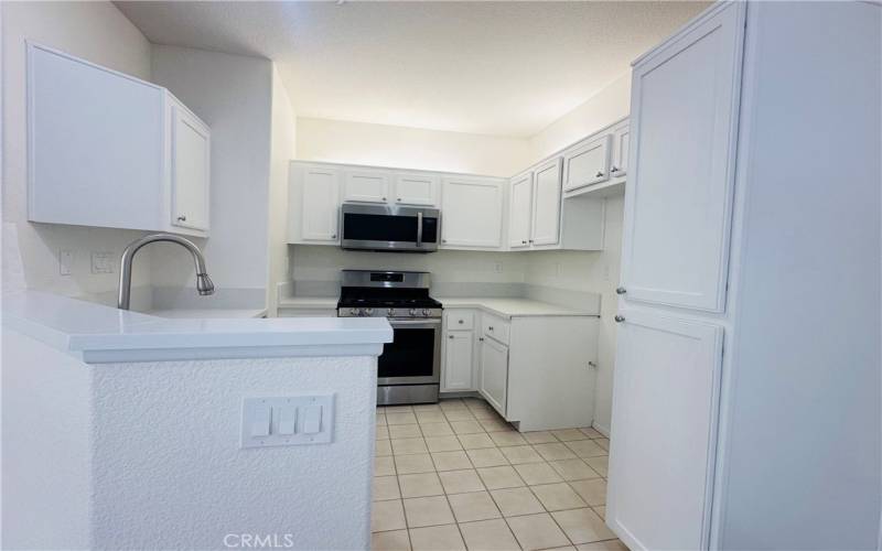 Freshly painted all white kitchen with newer appliances and stainless steel sink