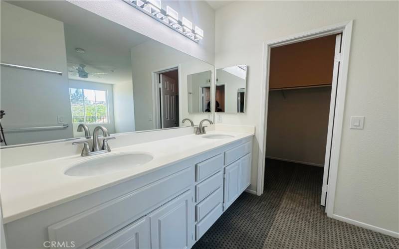 Large vanity with dual sinks. door to Walk-in closet