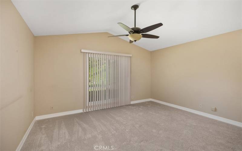 Primary bedroom with vaulted ceilings and new carpeting